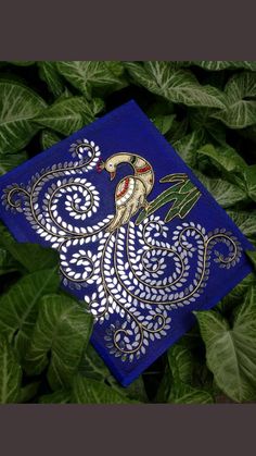 a blue cloth with an image of a bird on it in the middle of green leaves