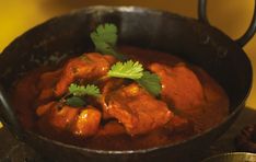 a pan filled with meat and garnished with cilantro