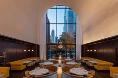 the interior of a restaurant with large windows and yellow booths set up in front of them