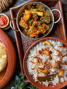 an assortment of food items displayed on wooden trays and serving platters with rice