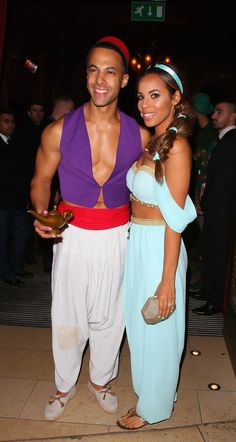 a man and woman dressed in costumes pose for the camera