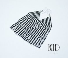 a pair of black and white beaded earrings on a white background with the word kcd written across it