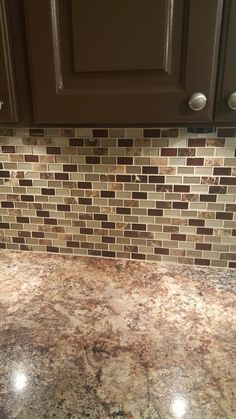 a granite counter top in a kitchen with brown cabinets