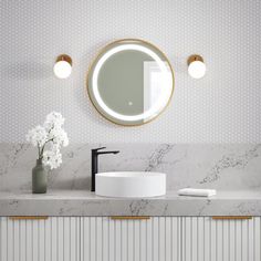 a bathroom with marble counter top and round mirror on the wall, along with two lights