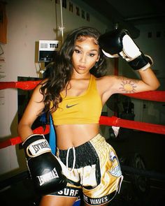 a woman in a yellow top and boxing gloves