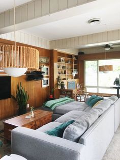 a living room with two couches and a table in front of a tv on the wall