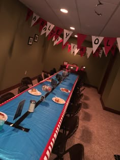 a long table is set up with plates and utensils on it for a party