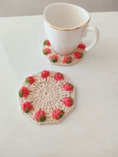 two crocheted coasters and a coffee cup on a table