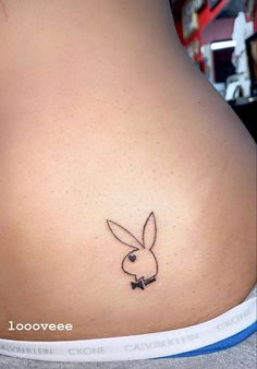 the back of a woman's stomach with a tattoo of a rabbit on it