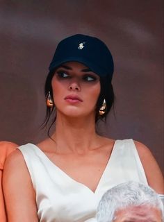 a woman in a white dress sitting next to an older man wearing a blue hat