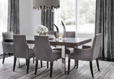 a dining room table with chairs and a chandelier hanging from it's ceiling