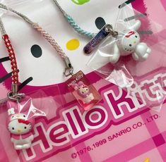 hello kitty keychains are sitting on a pink and white checkered tablecloth