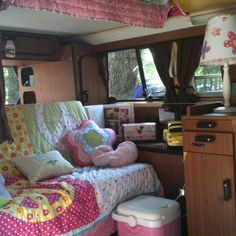 the interior of a camper with pink and yellow decor