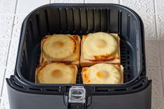 four slices of toasted bread in an air fryer on a white tile floor