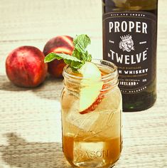 an apple cider next to a bottle of proper twelve