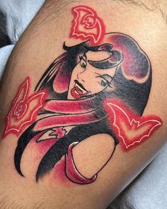 a woman's thigh with an image of snow white on it and red flowers