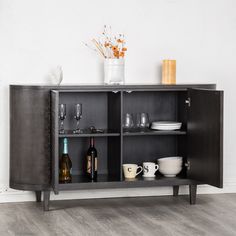 an entertainment center with wine glasses, plates and cups on the shelf next to it