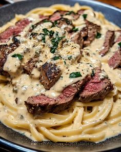 a plate of pasta with meat and sauce on it