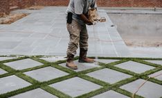 a man standing on top of a lush green field next to a fire hydrant