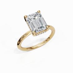 an emerald - cut diamond ring set in 18k yellow gold with diamonds on the band