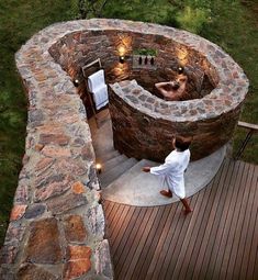 a man in white is walking towards an outdoor hot tub with lights on the side