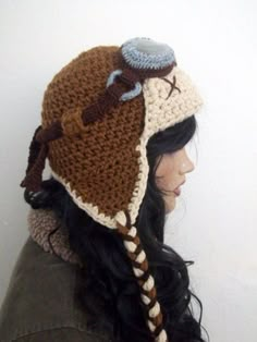 a woman wearing a brown and white crocheted hat with horns on it's head