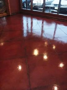 the floor is shiny red and there are lights on it in front of an open window