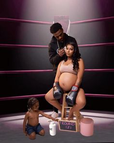 a woman sitting on top of a stool next to a baby in a boxing ring