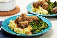 two plates filled with meat and broccoli covered in gravy next to a bowl of mashed potatoes