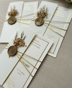 the wedding stationery is laid out on top of each other, with gold accents