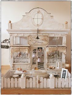 an old fashioned doll house is displayed on a table