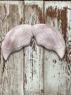 a fake moustache made out of wood on a wooden wall with peeling paint