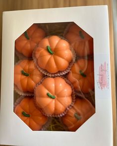 small orange pumpkins in a white box on a table