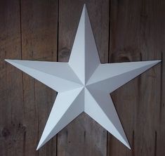 a metal star hanging on the side of a wooden fence