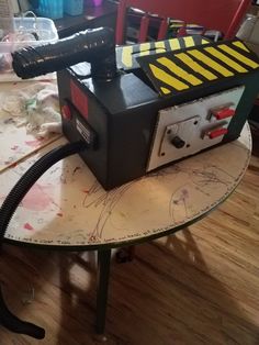 a black and yellow machine sitting on top of a table next to a red chair