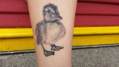 a small duck tattoo on the leg