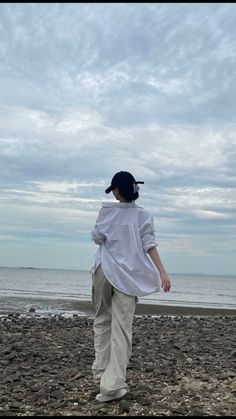 a young boy walking on the beach with his back to the camera