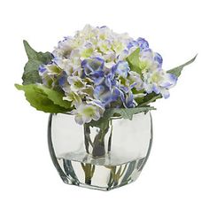 a glass vase filled with blue and white flowers