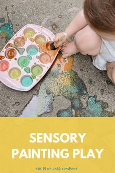 a toddler painting with the words sensory painting play on it's side