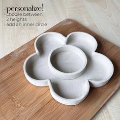 three white bowls sitting on top of a wooden cutting board