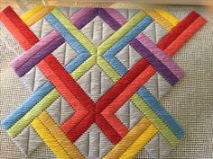 a close up of a piece of cloth with different colored squares on it and the stitching in the middle