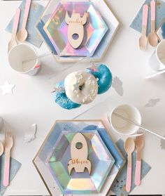 the table is set with colorful plates and utensils for children's birthdays