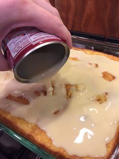 a person pouring sauce on top of a cake in the oven with it's crust