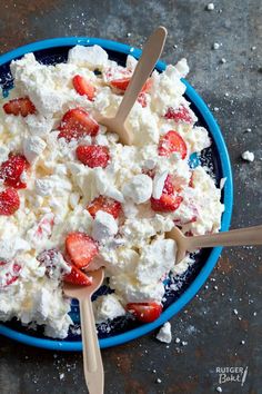 a blue bowl filled with cottage cheese and strawberries