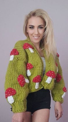 This women's cardigan has a thick knit for warmth and comfort. Knitted from fine and soft wool yarns, this cardigan will keep you warm in cold weather. The primary color of the cardigan is an intense green, which reflects the vitality and freshness of nature. The front of the cardigan is embroidered with red details. Red cork patterns add an elegant touch to the cardigan, while at the same time adding energy and vitality. These embroideries emphasize the elegance and originality of the cardigan. Mushroom Balloon, Knitted Mushroom, Mushroom Cardigan, Chunky Knitted Cardigan, Thick Knit Cardigan, Balloon Sleeve Cardigan, Thick Cardigan, Flower Cardigan, Cardigan Green