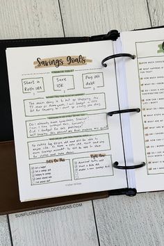 an open notebook with writing on it and some papers attached to the pages that are labeled savings goals