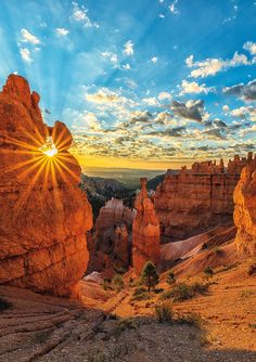 the sun shines brightly through the clouds above hoodoo canyon in utah's badlands