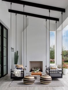 a living room filled with furniture next to a fire place under a skylight in front of a white wall