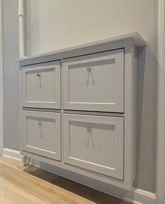 a white cabinet with four drawers in the corner