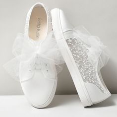 two white shoes with bows on them